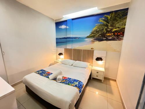 a bedroom with a large painting of a beach at Best View Hotel Bandar Sunway in Petaling Jaya