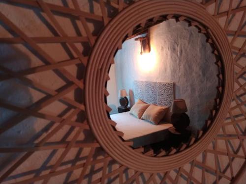 a bedroom with a bed in a round mirror at Casa da Volta - Alentejo - S. Julião in Portalegre