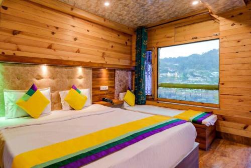 a bedroom with two beds and a large window at Goroomgo Vinayak Mall Road Lake View Nainital - Luxury Room - Best Hotel in Nainital in Nainital
