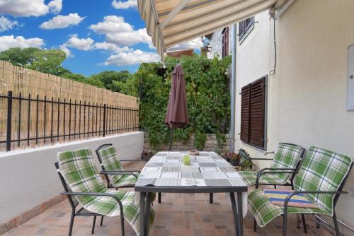 eine Terrasse mit einem Tisch, Stühlen und einem Sonnenschirm in der Unterkunft Studio für 4 Personen ca 85 qm in Premantura, Istrien Istrische Riviera in Premantura