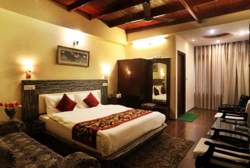 a bedroom with a bed and a couch in a room at Hotel Moon The Luxury Palace - Nainital in Nainital