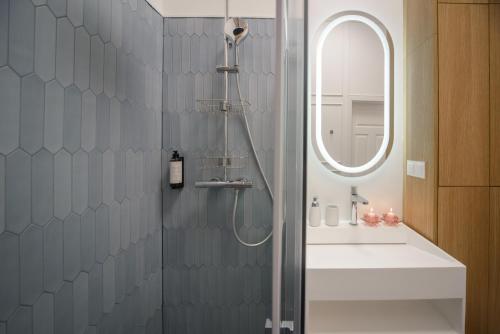 La salle de bains est pourvue d'une douche, d'un lavabo et d'un miroir. dans l'établissement Maya's Flats & Resorts 64 - 3 rooms apartment Chlebnicka, à Gdańsk