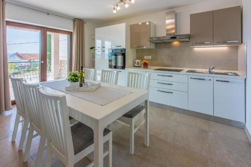 a white kitchen with a white table and chairs at Ferienwohnung für 7 Personen ca 100 qm in Crikvenica, Kvarner Bucht Crikvenica und Umgebung in Crikvenica