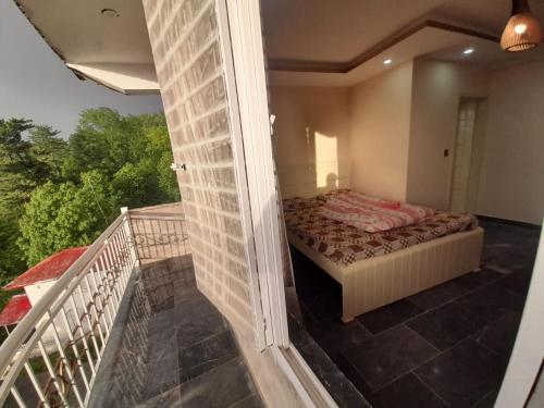 a bedroom with a bed on a balcony at Sajid Apartment Murree in Murree