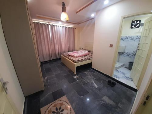 Sajid Apartment Murree في مورى: غرفة نوم صغيرة بها سرير وحمام