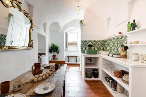 a kitchen with a wooden table and a mirror at THE GOODIES OF HISTORIC CENTER in Ostuni