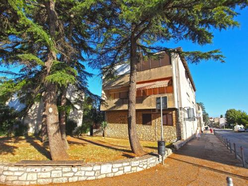 ein Gebäude mit zwei Bäumen neben einer Straße in der Unterkunft Studio für 3 Personen ca 32 qm in Fažana, Istrien Istrische Riviera - b55307 in Fažana