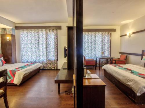 a hotel room with two beds and a table at Hotel Karma in Amritsar
