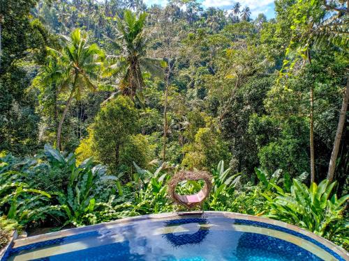 a swimming pool in the middle of a forest at Made Punias Jungle Paradise in Ubud