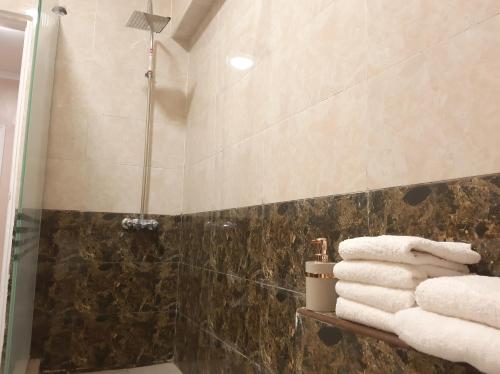 La salle de bains est pourvue d'une douche et de serviettes sur une étagère. dans l'établissement Moon Homes, au Caire