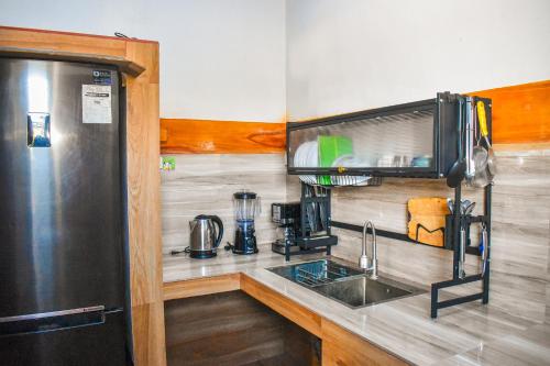 uma cozinha com um frigorífico de aço inoxidável e um lavatório em Casa de madera the wooden house em Cabuyao