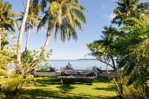 a picnic table in the grass next to the ocean at Mantaray Siargao in General Luna