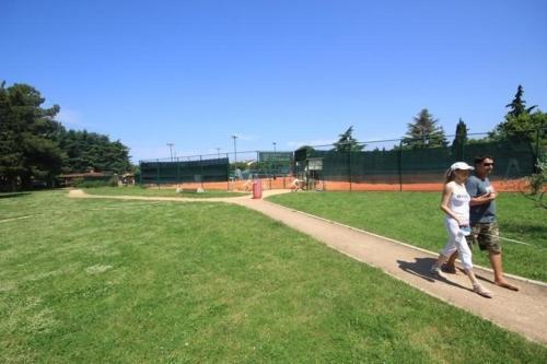 a man and a woman walking down a sidewalk at Ferienwohnung für 4 Personen ca 45 m in Novigrad, Adriaküste Kroatien Westküste von Istrien in Karpinjan
