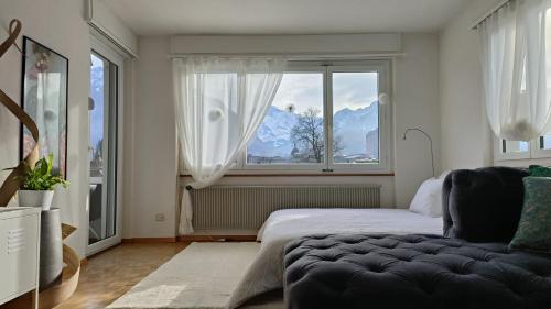 una camera con un letto e una grande finestra di Swisshomeliday a Interlaken