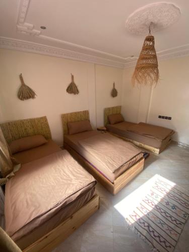 Cette chambre comprend 2 lits et un plafond. dans l'établissement Surf Bliss tamraght, à Tamraght Ouzdar