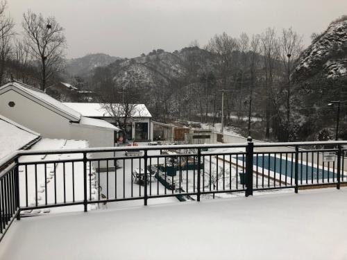 a balcony covered in snow with a fence at 隐谷私院The Great Wall Valley in Gubeikou