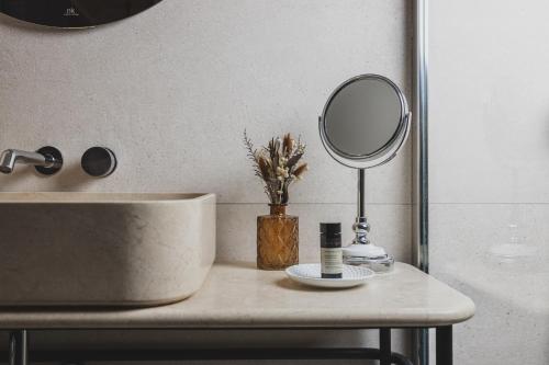 a bathroom counter with a sink and a mirror at Hôtel Singulier Bordeaux - Boutique Hôtel & Spa Anne Semonin in Bordeaux