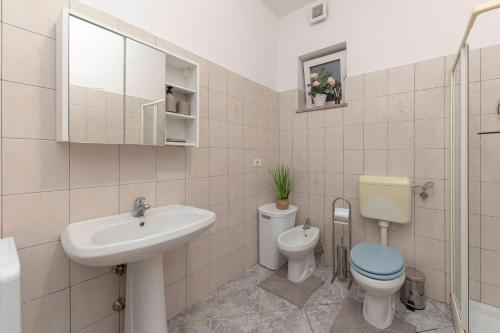 La salle de bains blanche est pourvue d'un lavabo et de toilettes. dans l'établissement Apartment Martin, à Koper