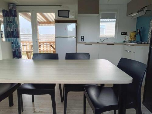 a kitchen with a table and chairs in a kitchen at Mobilhome Baltique in Oye-Plage