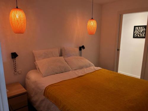 um quarto com uma cama com duas luzes por cima em Appartement de luxe urrgne em Urrugne