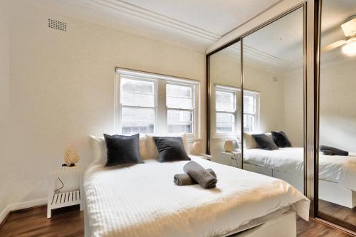 a bedroom with two beds and a large mirror at Charming 3 Bedroom on the edge of Downtown Herford St 2 E-Bikes Included in Sydney