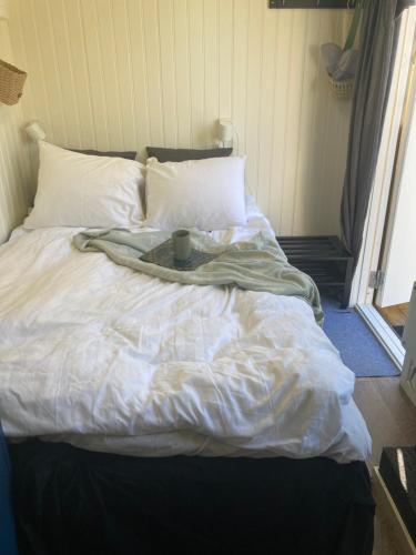 a bed with a blanket and a cup on it at Mysig ministuga på privat läge landet in Blentarp