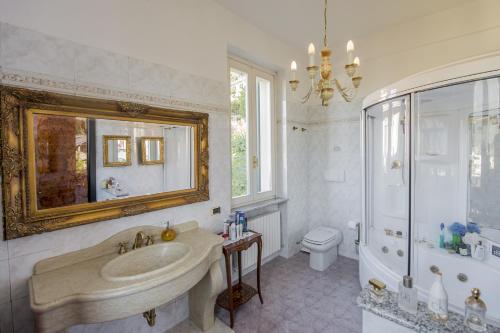 La salle de bains est pourvue d'un lavabo, de toilettes et d'un miroir. dans l'établissement Villa Puccini Bed & Breakfast, à Lecco