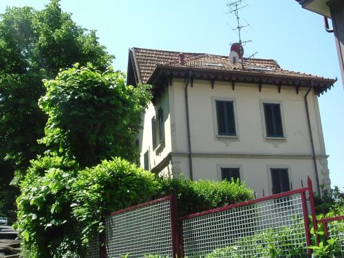 a white building with a roof on top of it at Villa Puccini Bed & Breakfast in Lecco