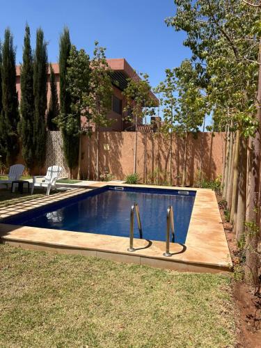 - une piscine avec 2 poignées en métal dans la cour dans l'établissement Villa djelloul, à Marrakech