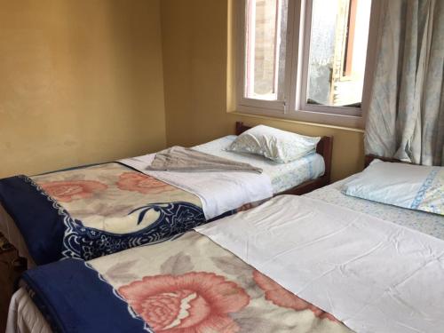 two beds sitting next to each other in a room at Hotel Lumbini Resort in Pokhara