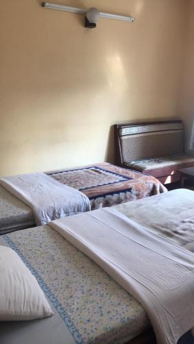 3 camas están alineadas en una habitación en Hotel Lumbini Resort, en Pokhara