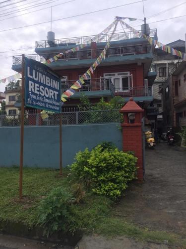 a building with a sign in front of a house at Hotel Lumbini Resort in Pokhara