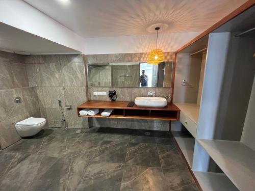 La salle de bains est pourvue d'un lavabo et de toilettes. dans l'établissement nKAaSA hotel Personal Suites, à Raxaul