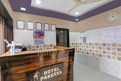 a hotelacist counter with a clock on the wall at OYO Flagship Hotel Pakeeza in Mumbai