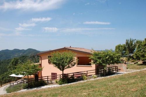 una casa en una colina con árboles delante de ella en Ferienwohnung für 1 Personen 3 Kinder ca 60 qm in Apecchio, Marken Provinz Pesaro-Urbino en Apecchio