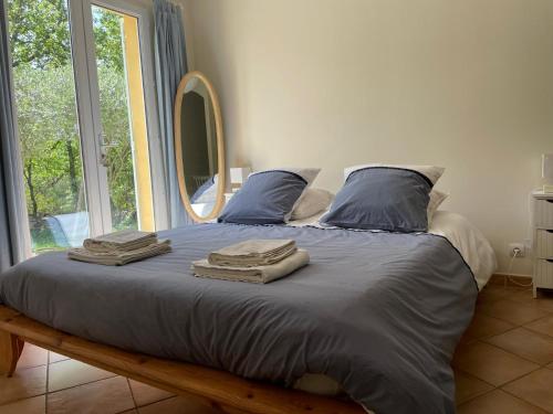 ein Bett mit Handtüchern in einem Zimmer mit Fenster in der Unterkunft Les marguerites in Vers-Pont-du-Gard