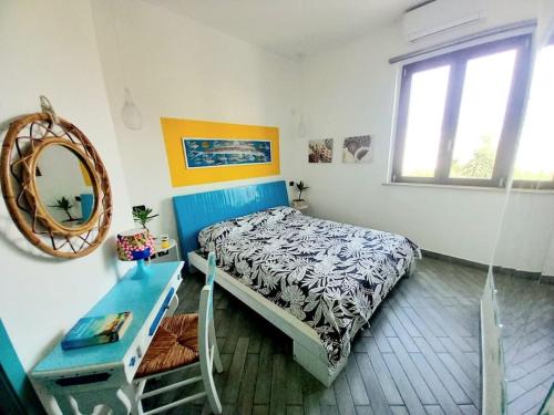 a bedroom with a bed and a table and a mirror at Villa Mondello Terraces & Jacuzzi in Mondello