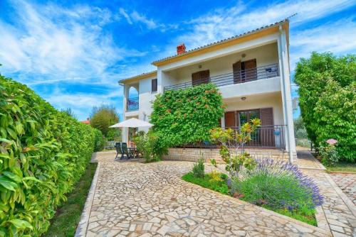 une maison avec un jardin et une terrasse dans l'établissement Ferienwohnung für 4 Personen ca 35 qm in Fažana, Istrien Istrische Riviera, à Valbandon