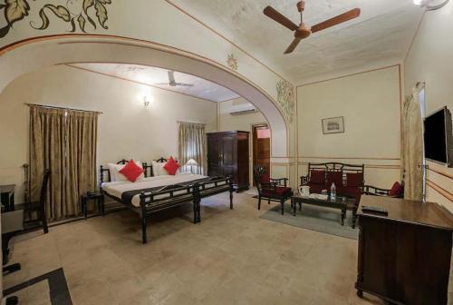 een grote kamer met een bed en een televisie bij Roop Vilas Palace in Nawalgarh