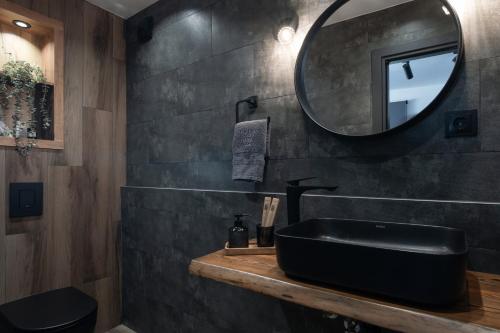a bathroom with a black sink and a mirror at StayInn Luxury Apartments in Nea Kalikratia