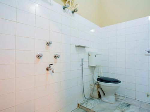 a bathroom with a toilet with a black seat at HOTEL BREEZE NEW JALPAIGURI in Siliguri