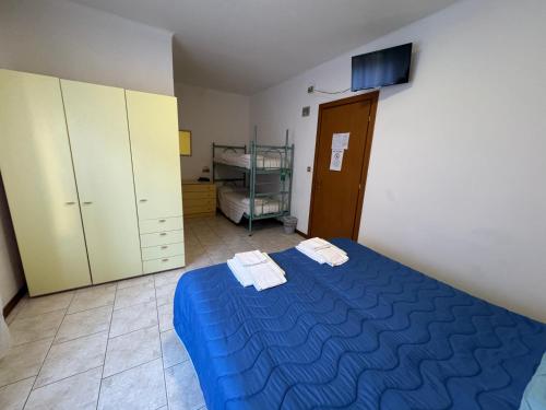 a bedroom with a blue bed with towels on it at Hotel Villa Augusta in Grado
