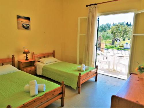 a bedroom with two beds and a balcony at Nikos Apartments 1 in Kavos