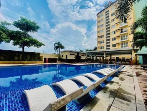 Jalang的住宿－Holland Park Condominium，一座带躺椅的游泳池位于大楼旁