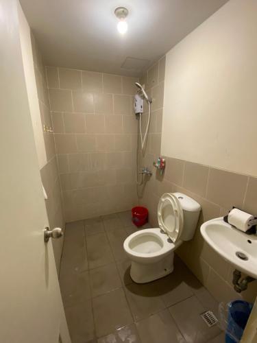 łazienka z toaletą i umywalką w obiekcie Holland Park Condominium w mieście Jalang