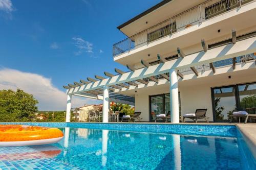 ein Schwimmbad vor einem Gebäude in der Unterkunft Ferienhaus mit Privatpool für 8 Personen ca 234 m in Malinska, Kvarner Bucht Krk in Malinska