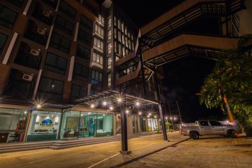 a building with lights on a street at night at Phu Dahla Apartments in Ban Khlong Haeng