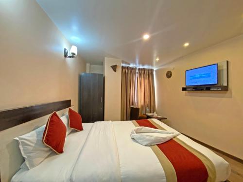 a bedroom with a large bed with a tv on the wall at Hotel Readers Inn Pvt.Ltd in Kathmandu