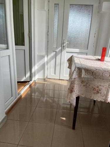 Cette chambre dispose d'une table et d'une porte avec fenêtre. dans l'établissement Casa David, à Tulcea