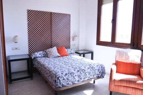 1 dormitorio con 1 cama, 1 silla y 1 ventana en SE - Peaceful Shiny Apartment Near Fibes en Sevilla